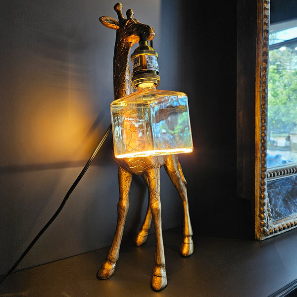 GIRAFFE HOLDING LIGHTBULB TABLE LAMP, GOLD